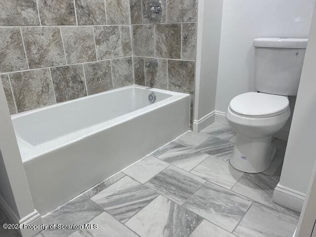 bathroom with washtub / shower combination and toilet