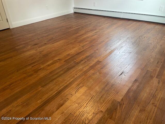 interior details with wood-type flooring and baseboard heating