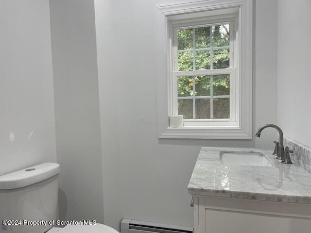 bathroom with vanity, toilet, and a baseboard heating unit