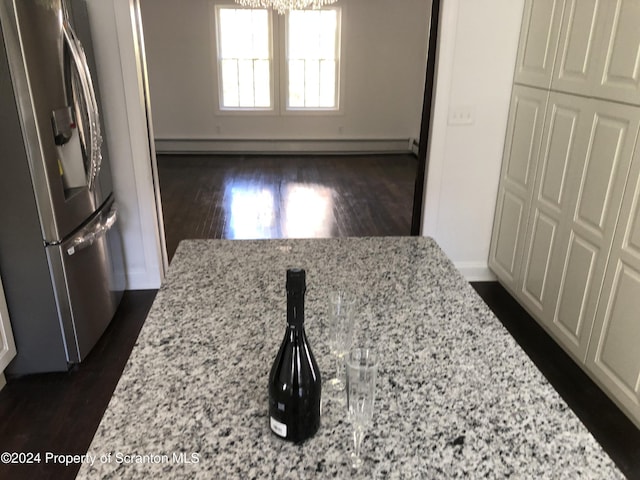 kitchen featuring stainless steel fridge and light stone counters