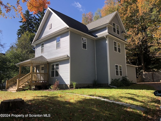 view of home's exterior featuring a yard and a porch