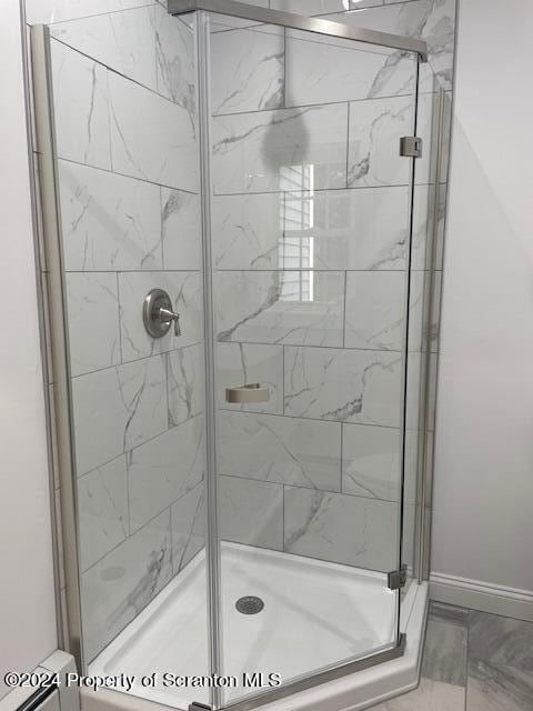 bathroom with a shower with door