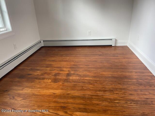 unfurnished room with dark hardwood / wood-style flooring