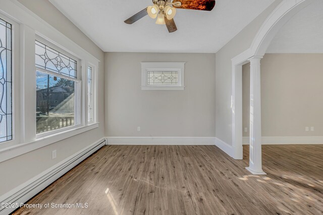 unfurnished room with a textured ceiling, decorative columns, ceiling fan, and dark wood-type flooring