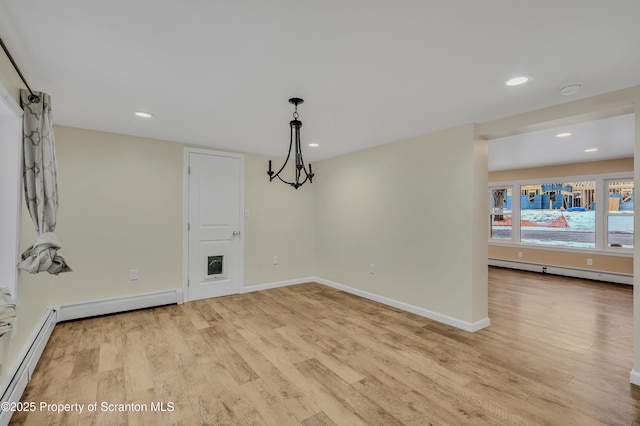 unfurnished dining area with baseboard heating and light hardwood / wood-style flooring