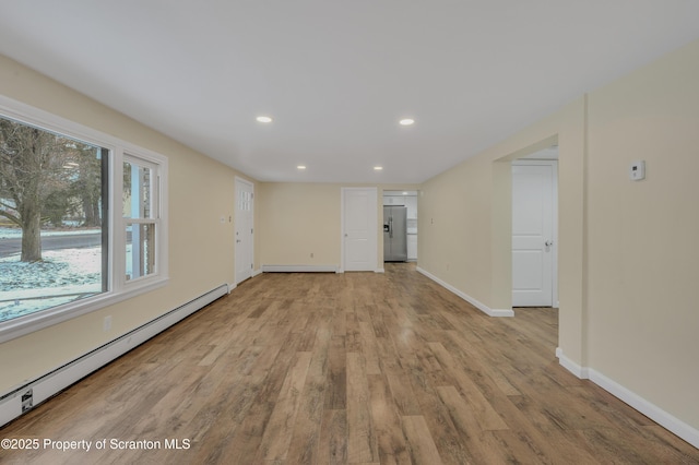 spare room featuring light hardwood / wood-style floors and a baseboard heating unit