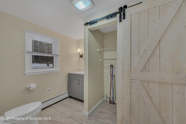 bathroom with toilet, vanity, and a baseboard heating unit