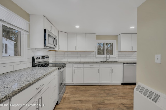 kitchen featuring appliances with stainless steel finishes, white cabinetry, and sink