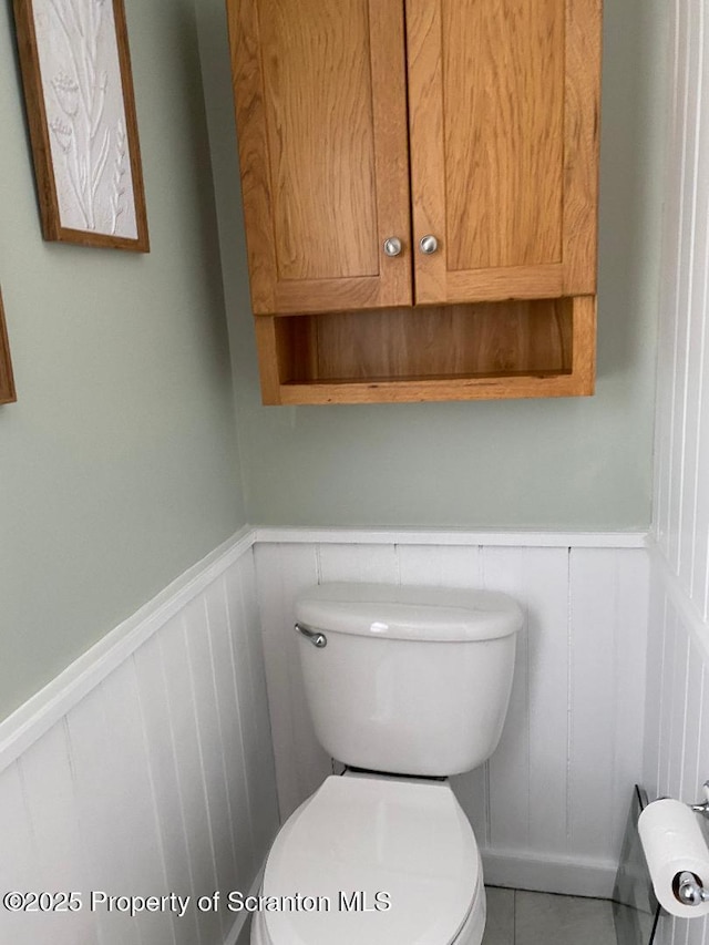 bathroom featuring wainscoting and toilet