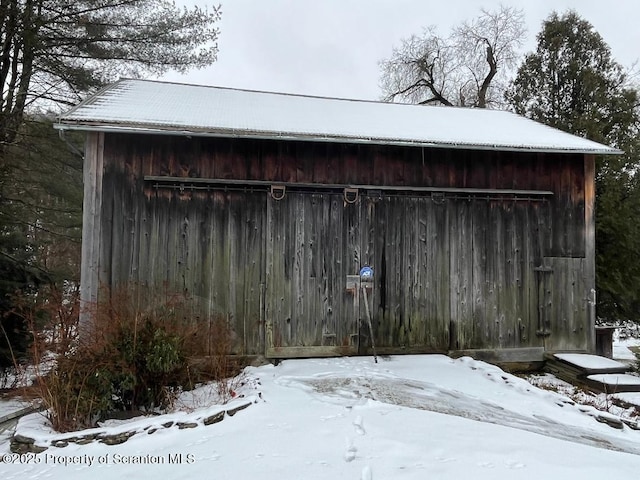 snow covered structure featuring an outdoor structure