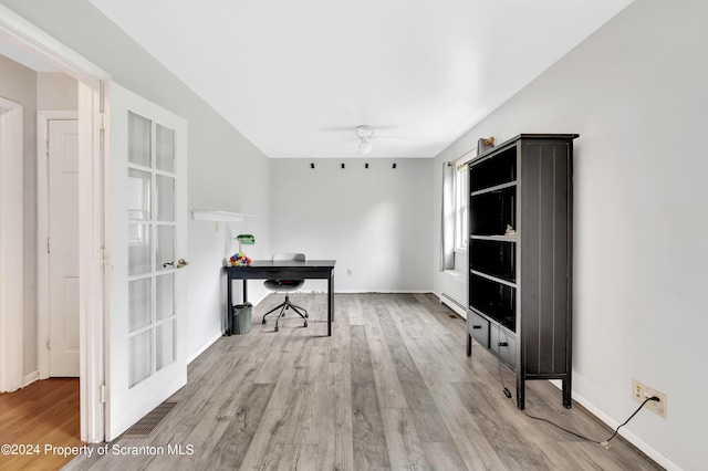 office space with ceiling fan, a baseboard heating unit, and light hardwood / wood-style flooring