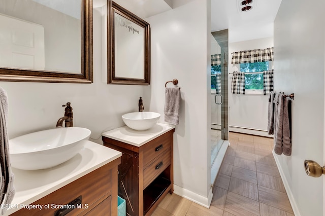 bathroom with vanity, baseboard heating, and walk in shower