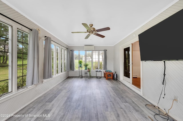 unfurnished sunroom featuring ceiling fan and a wall unit AC