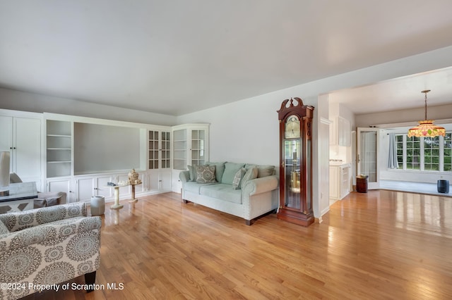 living room featuring light hardwood / wood-style floors and a notable chandelier