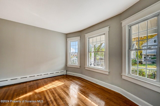 empty room with a baseboard radiator and wood-type flooring