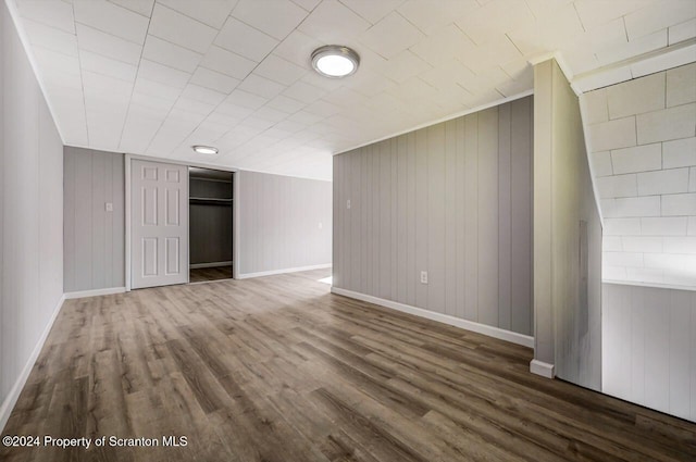 interior space with dark wood-type flooring and wooden walls