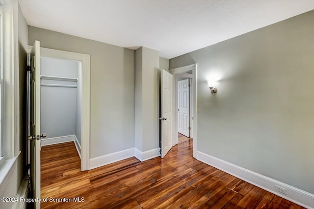 unfurnished bedroom with hardwood / wood-style floors and a closet