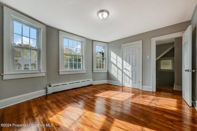 empty room featuring hardwood / wood-style floors and baseboard heating