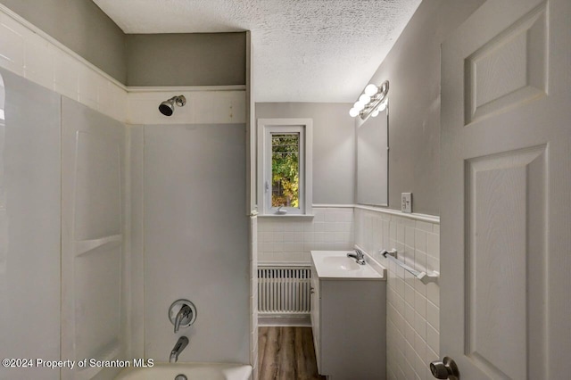 1319 Pine St, Scranton, PA 18510 - full bath with radiator, vanity, tile walls, shower / bathtub combination, and a textured ceiling