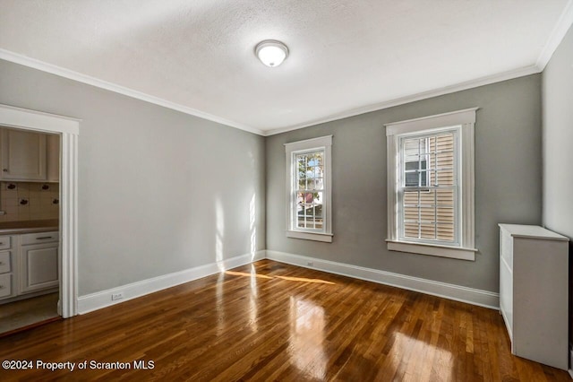 spare room featuring crown molding, a textured ceiling, and dark hardwood / wood-style flooring