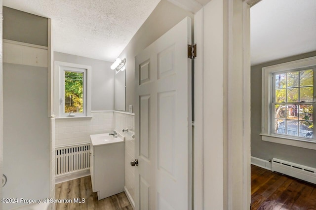 1319 Pine St, Scranton, PA 18510 - bathroom with radiator, vanity, wood finished floors, baseboard heating, and a textured ceiling