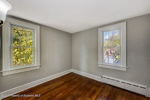 1319 Pine St, Scranton, PA 18510 - spare room with a baseboard heating unit, dark wood finished floors, and plenty of natural light