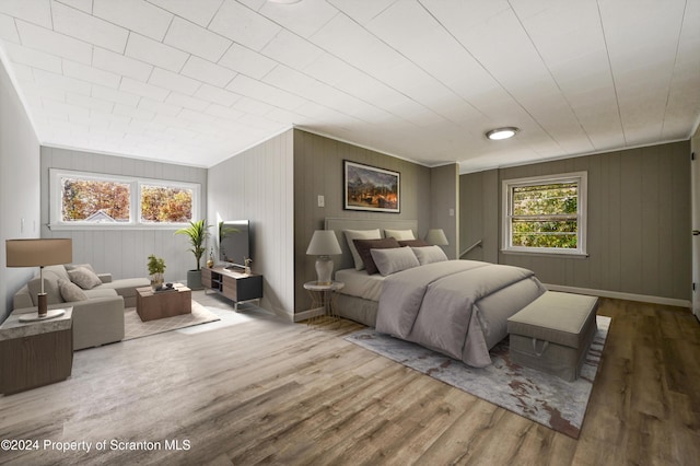 bedroom with wood-type flooring and wood walls