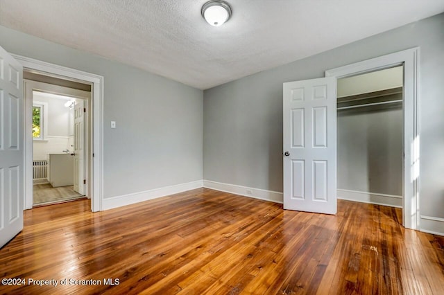 1319 Pine St, Scranton, PA 18510 - unfurnished bedroom with radiator, wood-type flooring, a closet, and a textured ceiling