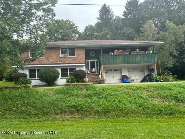 split foyer home featuring a front yard and a garage