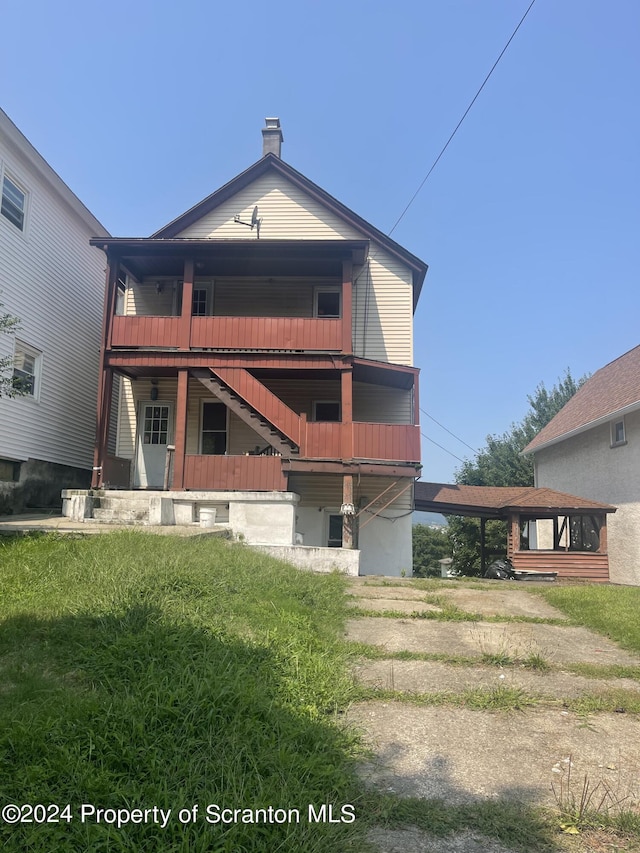 rear view of property featuring a balcony