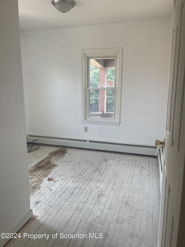 unfurnished room featuring light hardwood / wood-style floors and a baseboard radiator