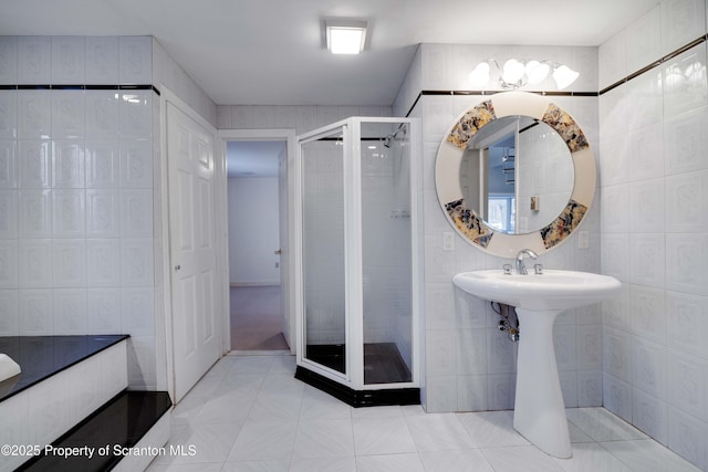 bathroom featuring tile patterned flooring, tile walls, and an enclosed shower