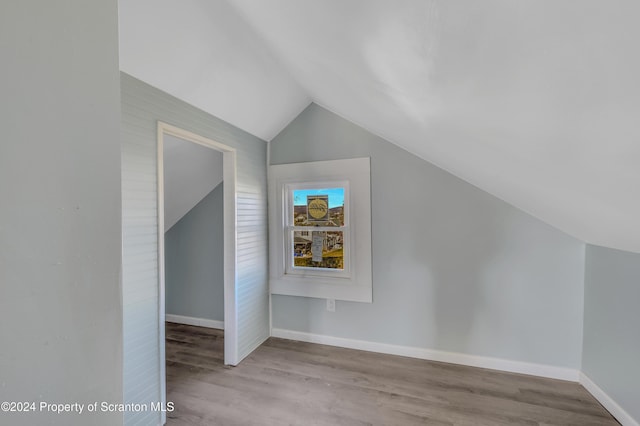 bonus room with light wood-type flooring and vaulted ceiling