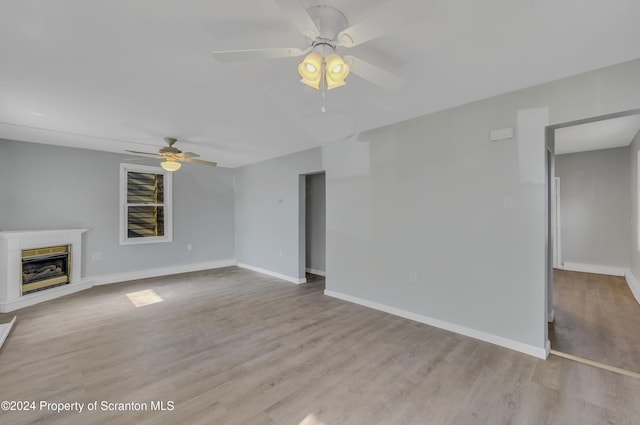 unfurnished living room with ceiling fan and light hardwood / wood-style flooring