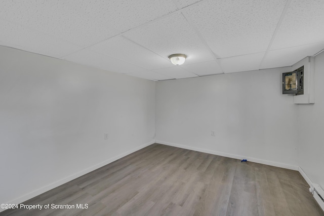 unfurnished room with light wood-type flooring and a paneled ceiling