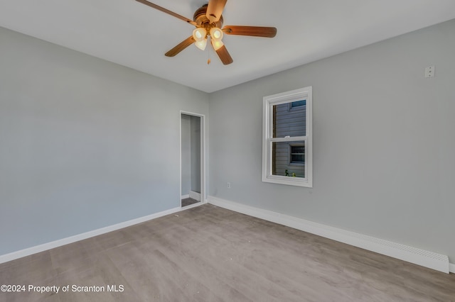 empty room with ceiling fan and light hardwood / wood-style floors