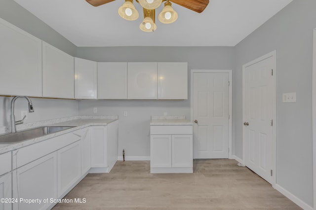 kitchen featuring ceiling fan, light hardwood / wood-style floors, white cabinetry, and sink