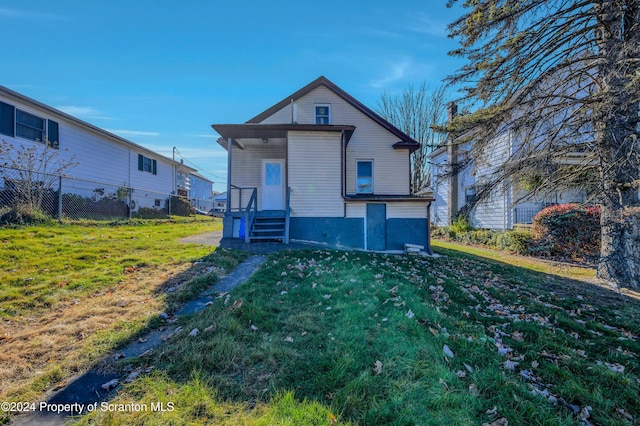 rear view of property with a yard