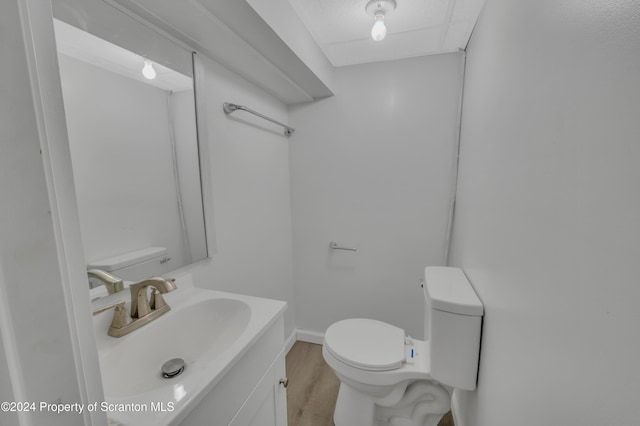 bathroom with vanity, hardwood / wood-style flooring, and toilet