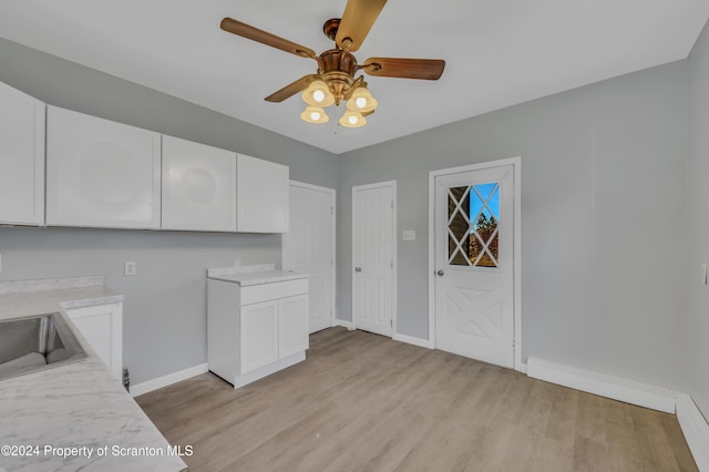 kitchen featuring ceiling fan, light hardwood / wood-style flooring, white cabinets, and sink