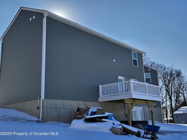 view of snowy exterior with a deck