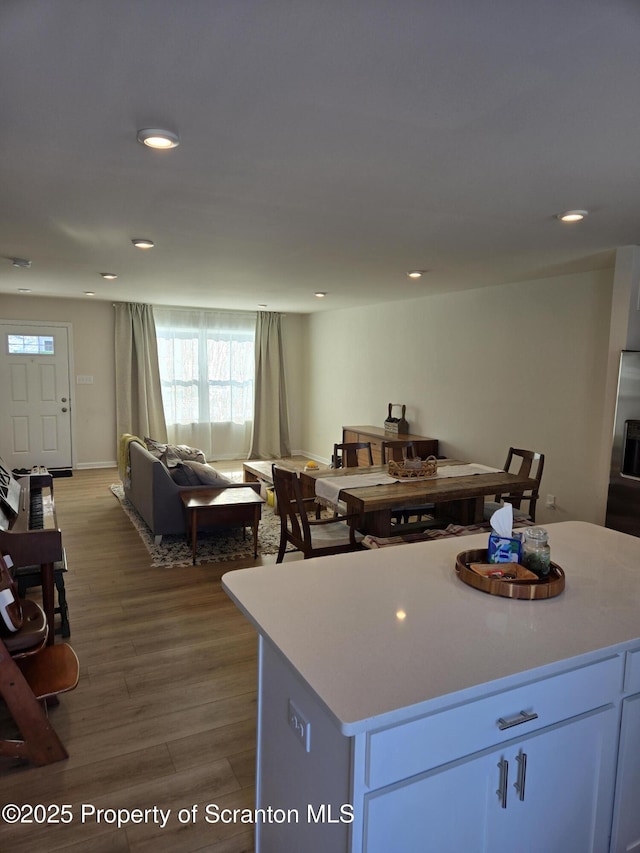 kitchen featuring white cabinetry, a center island, and light hardwood / wood-style flooring