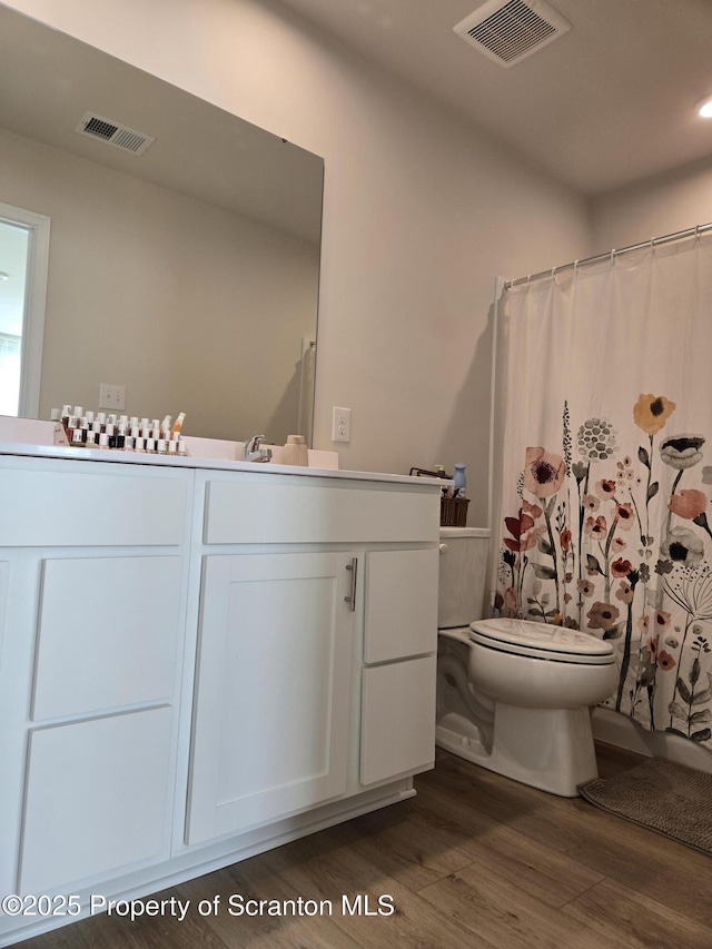 bathroom with vanity, hardwood / wood-style floors, curtained shower, and toilet