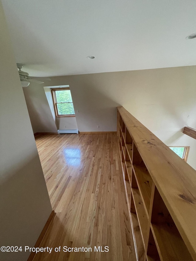 additional living space with a baseboard radiator and light wood-type flooring