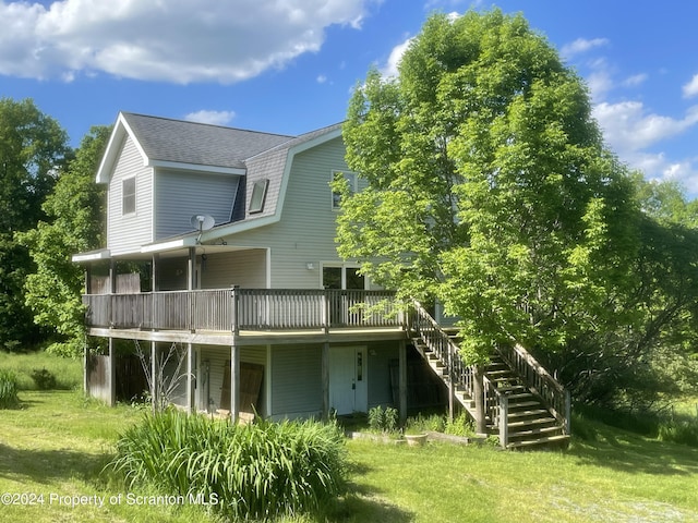 rear view of property featuring a lawn and a wooden deck