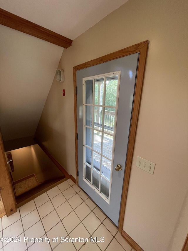 entryway with lofted ceiling with beams and light tile patterned flooring