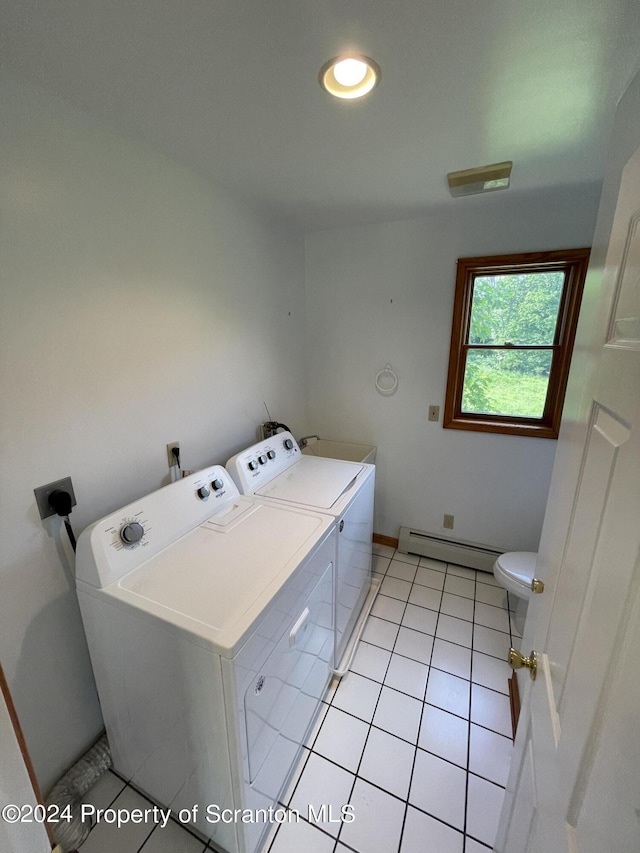 clothes washing area featuring independent washer and dryer, light tile patterned floors, and a baseboard heating unit