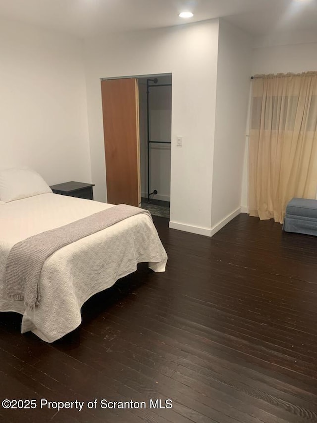 bedroom with dark hardwood / wood-style floors