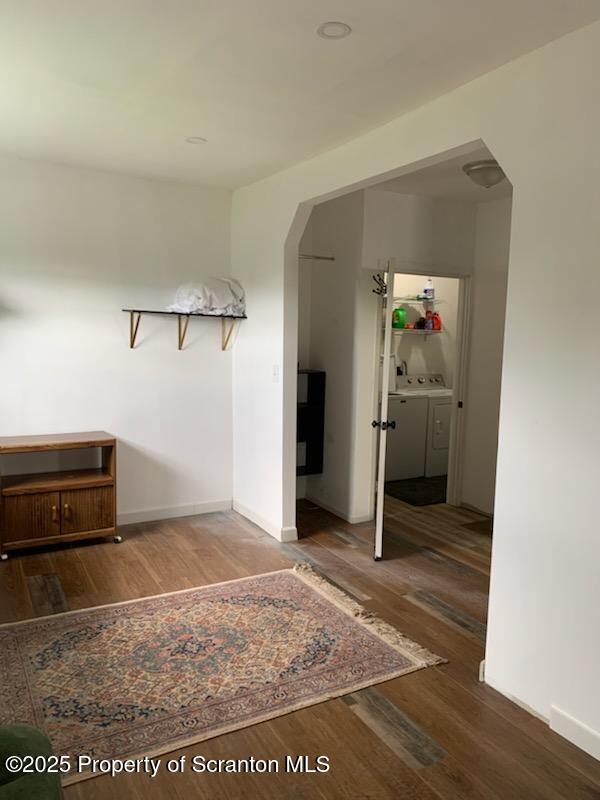 hallway with hardwood / wood-style floors and washing machine and dryer