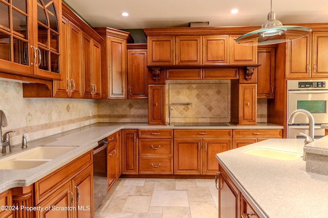 kitchen with black appliances, backsplash, sink, and hanging light fixtures